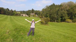 Me with my arms out on a green field